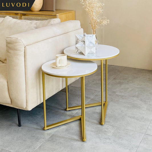 Two marble top side tables with gold frames in a living room setting.