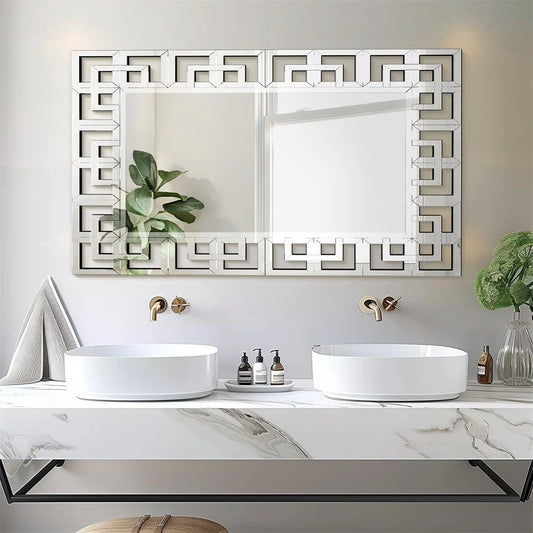 Bathroom vanity with two sinks, decorative mirror, and small plants.