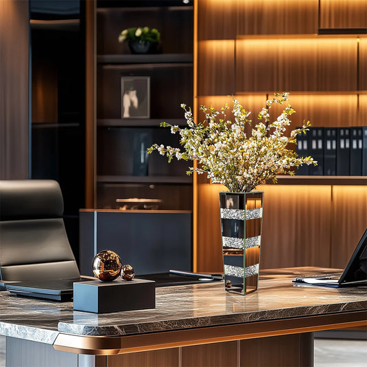 Modern office desk with decorative vase, laptop, and office chair.