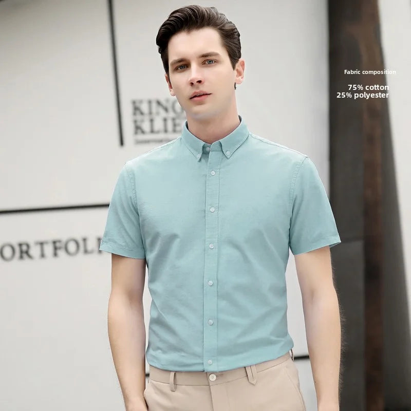 Man wearing a light blue short-sleeve shirt with a blurred background