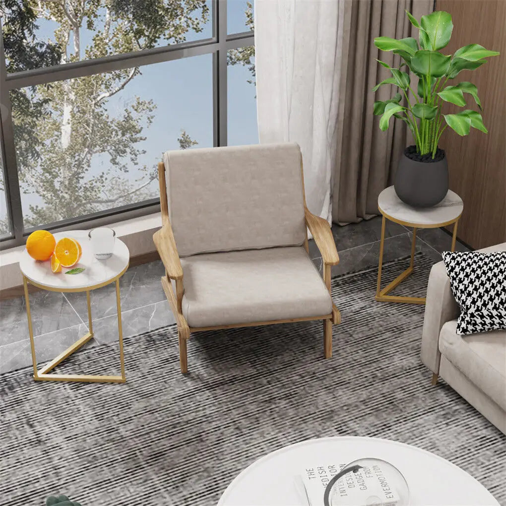 Modern living room with a beige armchair, side tables, and a plant.