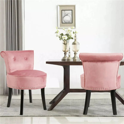 Two pink chairs in front of a wooden table with decorative items on a light-colored floor.