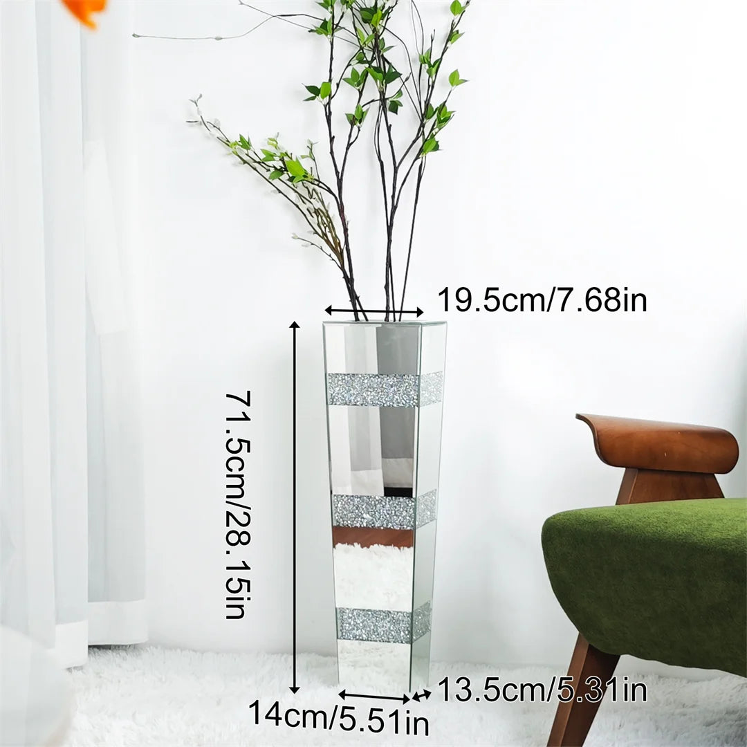 Clear glass vase with decorative elements and measurements, placed indoors.