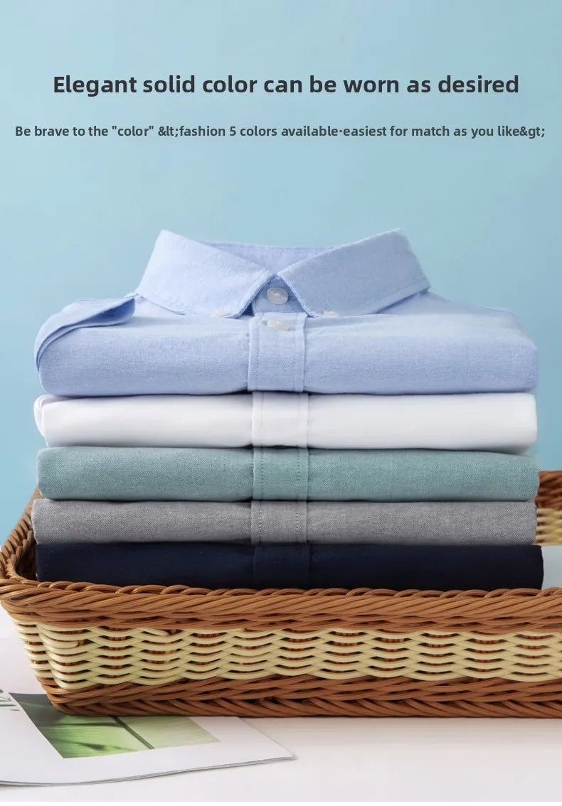 Stack of folded shirts in various colors on a woven basket with a light blue background.