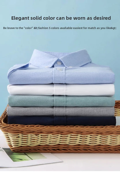 Stack of folded shirts in various colors on a woven basket with a light blue background.