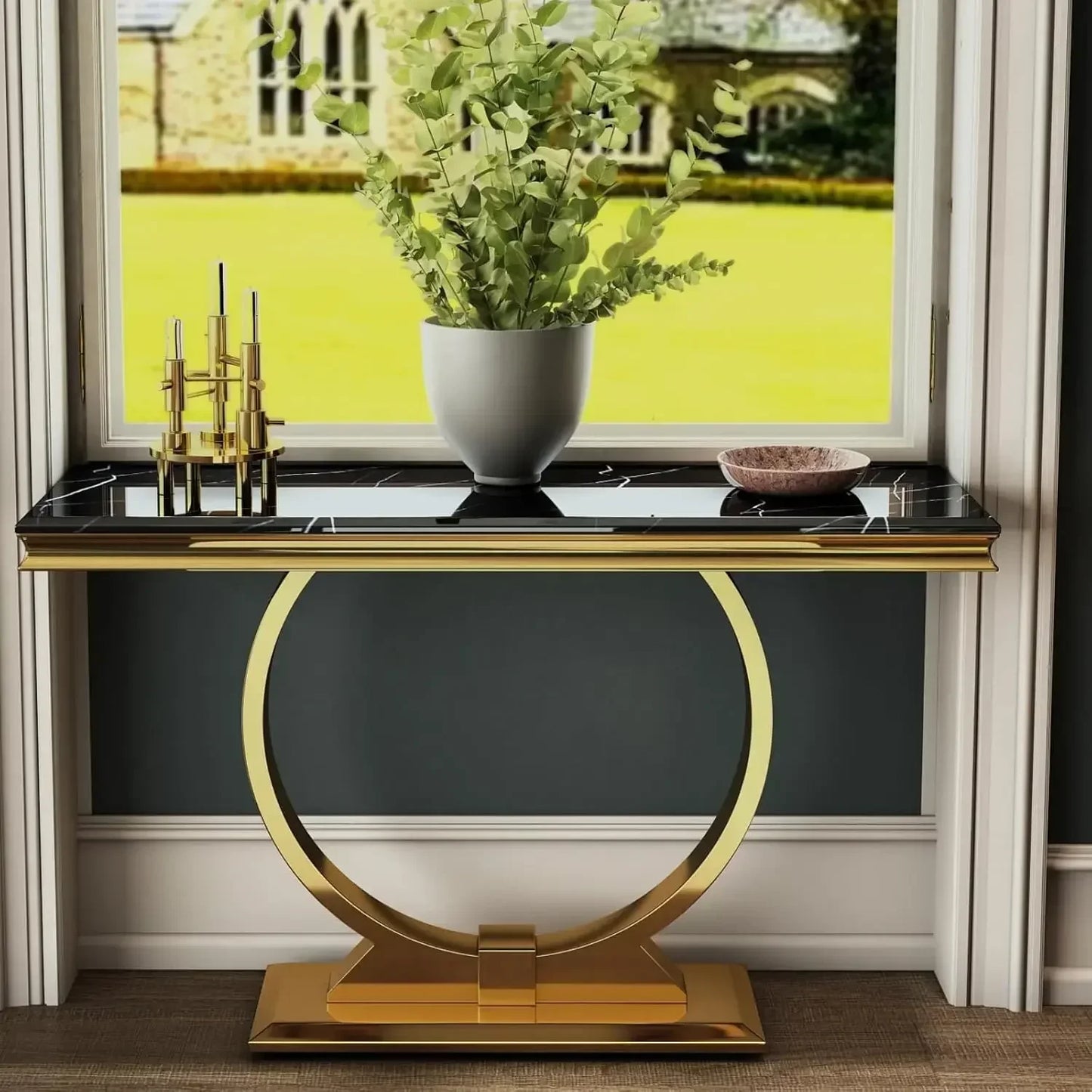 Decorative console table with gold base and black top in a room with a window.