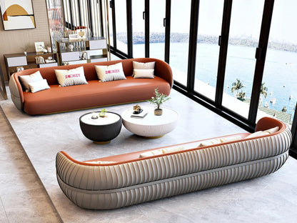 Modern living room with a brown sofa and a curved beige sofa in front of large windows with a view of water.