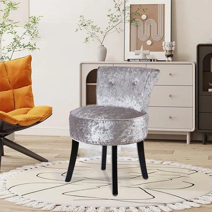 Gray velvet chair in a stylish room with a white cabinet and decorative items.