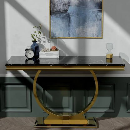 Decorative console table with gold base and black top in a room setting.