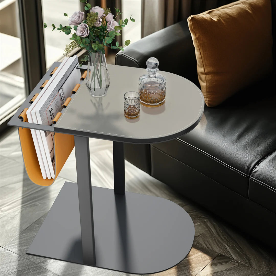 Modern side table with a vase, glasses, and decanter next to a black leather sofa.