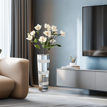 Modern living room with a vase of white flowers, a TV, and a sofa.