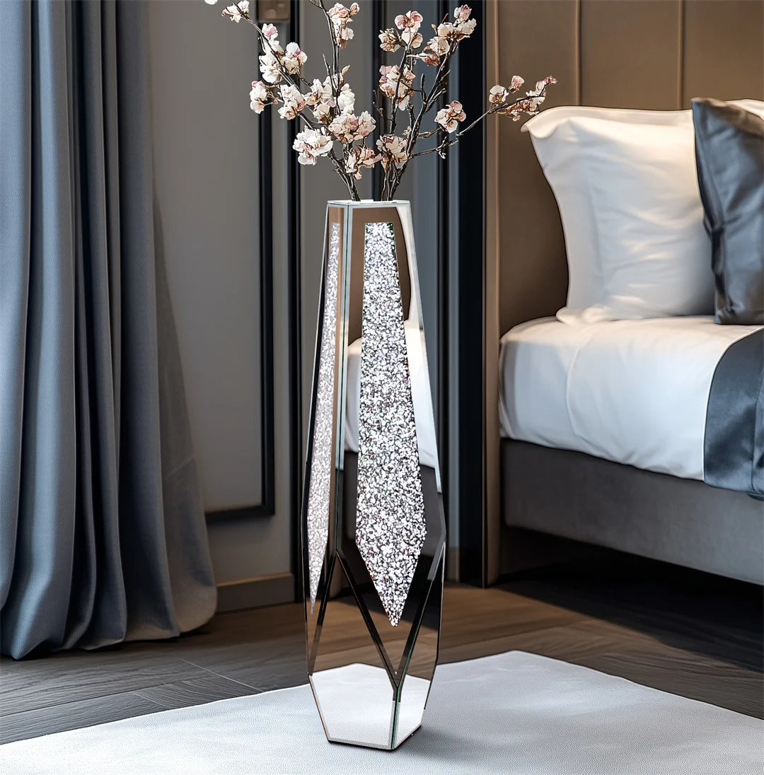 Decorative vase with floral arrangement on a surface in a room with a bed and curtains.