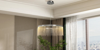 Chandelier hanging in a room with curtains and a plant