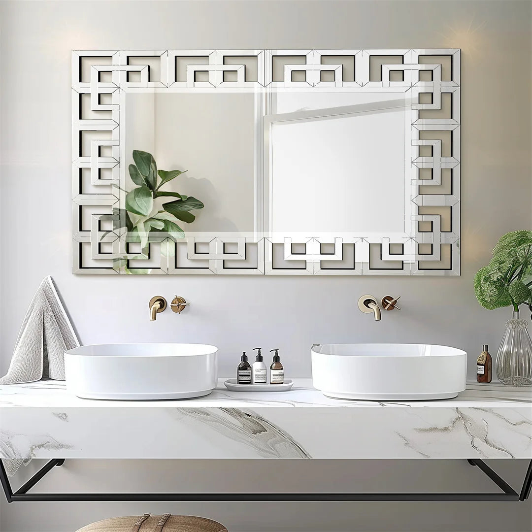 Bathroom vanity with two sinks, decorative mirror, and small plants.
