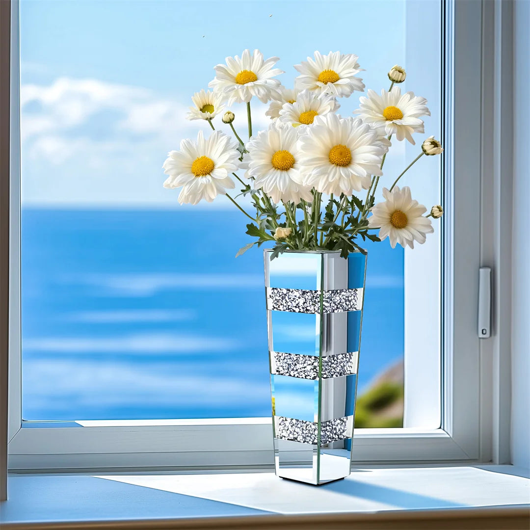 Clear glass vase with white flowers on a windowsill with a blue sky background