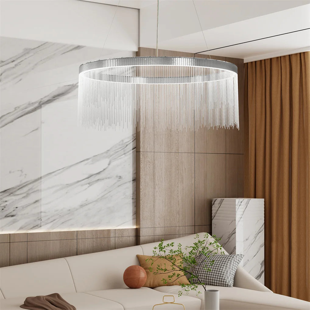 Modern living room with a chandelier, marble wall, and beige sofa.