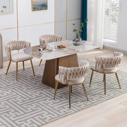 Dining room with marble table and upholstered chairs on a patterned rug.