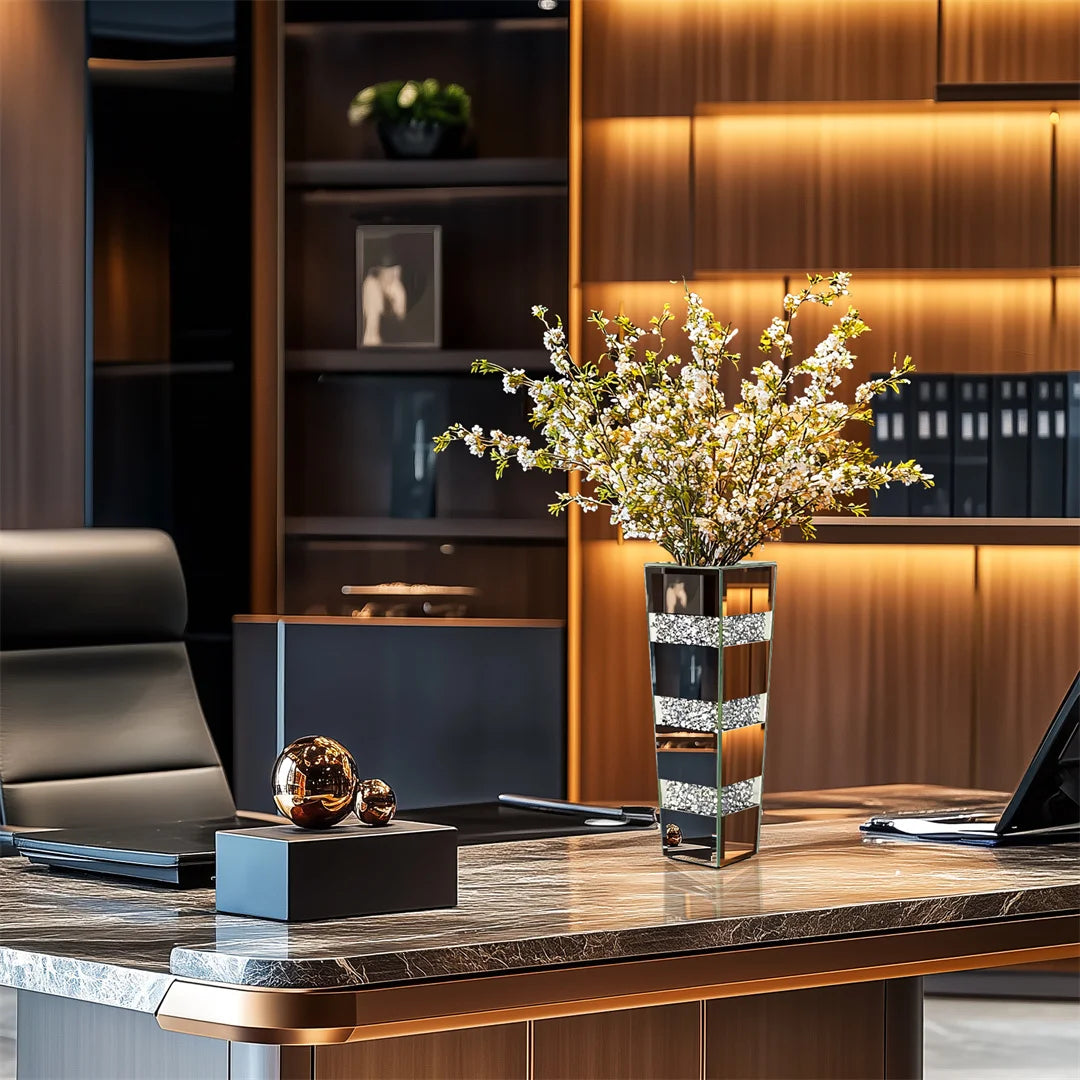 Modern office desk with decorative vase, laptop, and office chair.