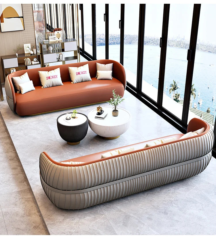 Modern living room with brown and beige sofas, coffee table, and decorative items.