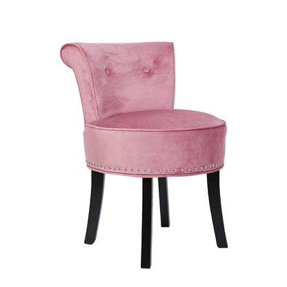Pink velvet chair with black legs on a white background