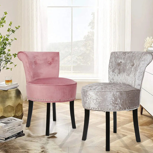 Pink and gray velvet chairs in a room with a window and decorative items.