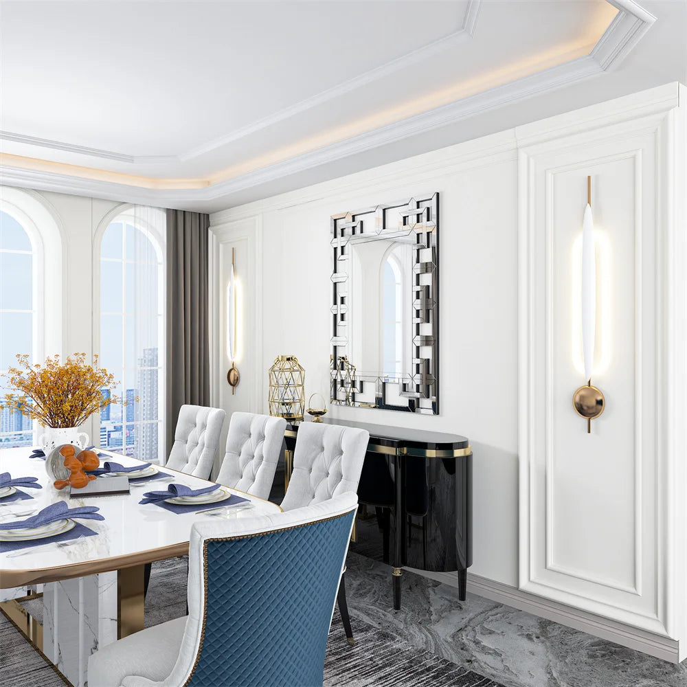 Modern dining room with white chairs, blue accents, and a large mirror on the wall.
